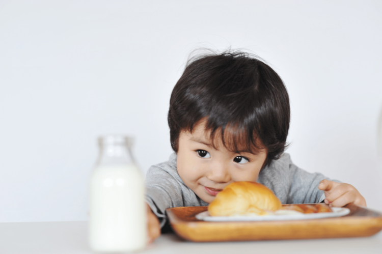 Trẻ ăn bánh và uống sữa 