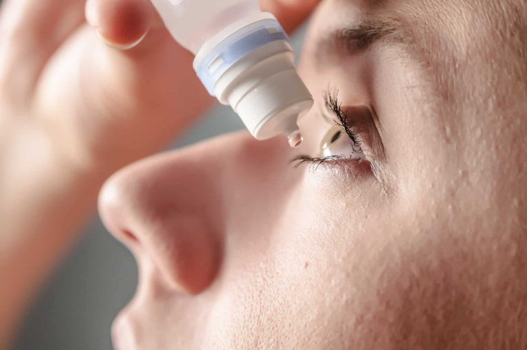 Nhỏ thuốc làm giãn đồng tử để kiểm tra mắt bằng kính hiển vi
